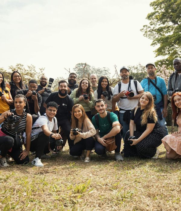 Diverse group of people in various yoga poses in a sunny park.